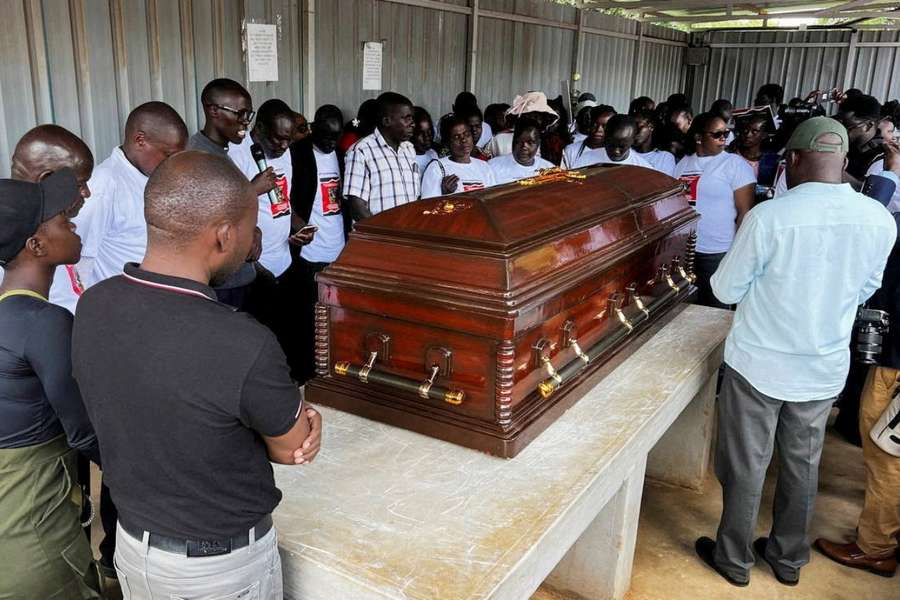 Family members mourn and react next to the coffin of Cheptegei