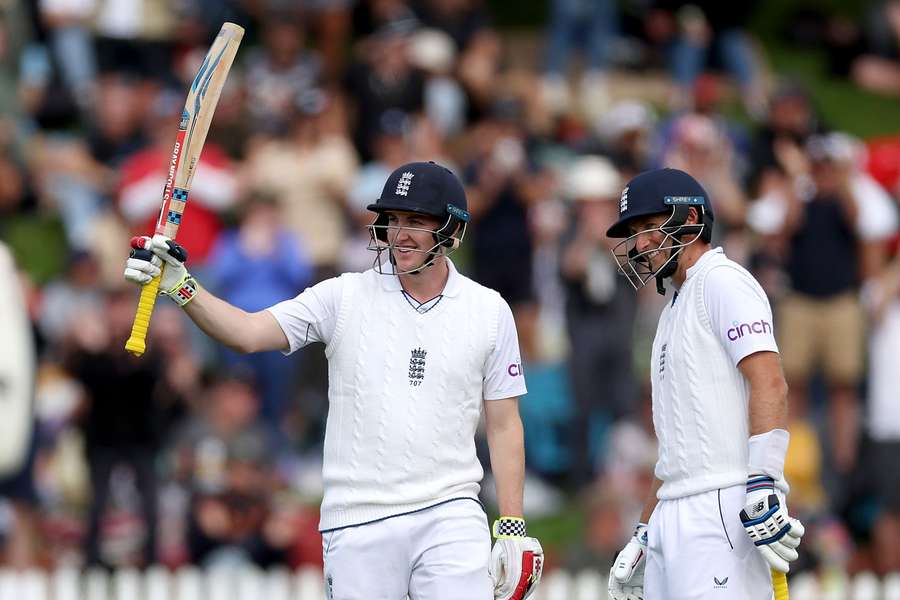 England's Harry Brook (L) celebrates 150 runs with teammate Joe Root