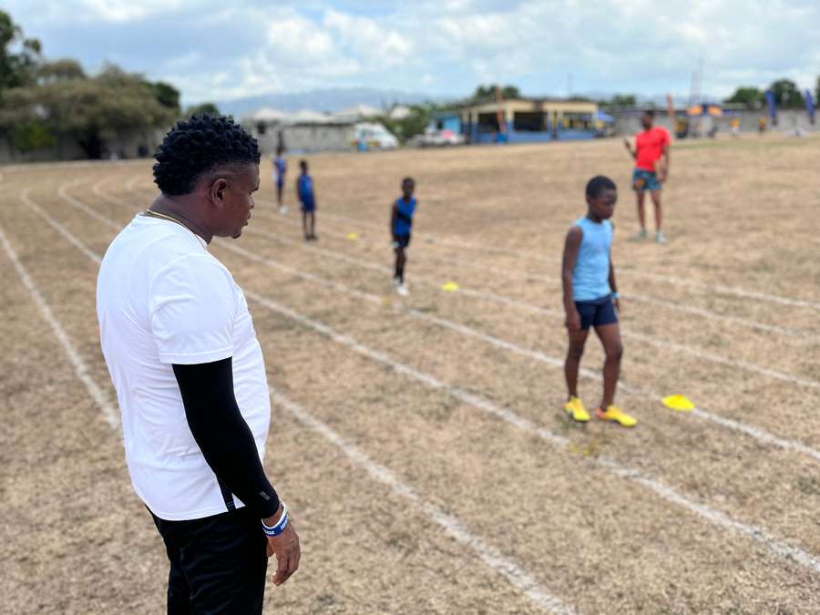 Coach Shanti Blake (L) watches children compete at the Richmond Park Sports Complex in Kingston