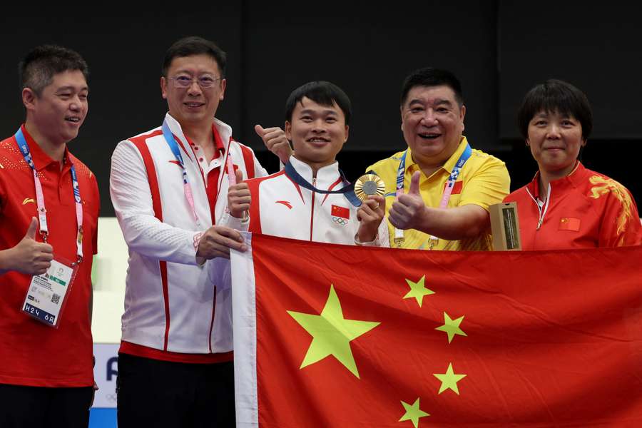 China's Xie Yu (centre) poses with team members