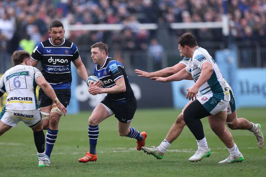 Finn Russell of Bath runs at Jack Clement of Gloucester