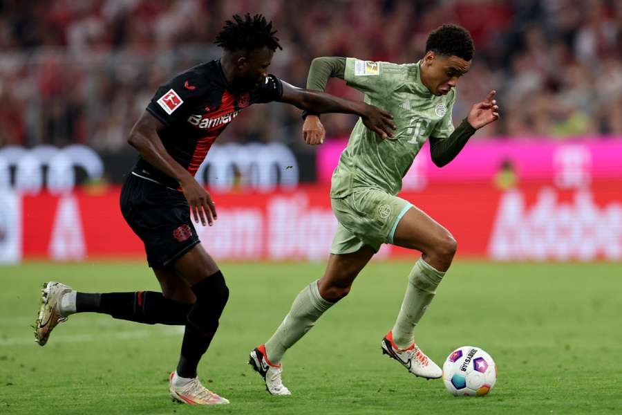 Jamal Musiala van Bayern (r) en Edmond Tapsoba van Leverkusen (l)