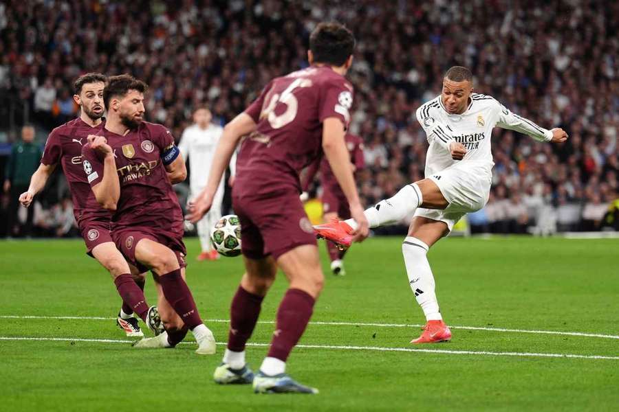 Real Madrid's Kylian Mbappe has a shot blocked by Manchester City's Ruben Dias (second left) 