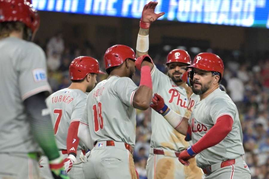 Phillies hitter Kyle Schwarber (12) is congratulated by Trea Turner, Johan Rojas and Austin Hays after a three-run home run against the Dodgers