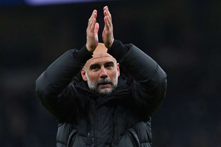 Pep Guardiola applauds fans on the pitch after the English FA Cup fourth round football match between Tottenham Hotspur and Manchester City 