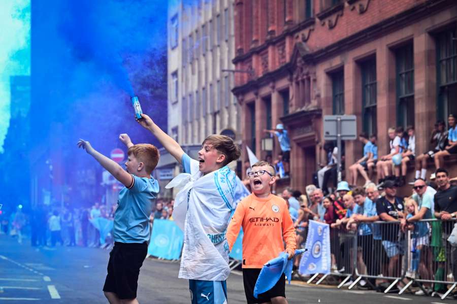 Supporters celebrate as they wait for the arrival of the players