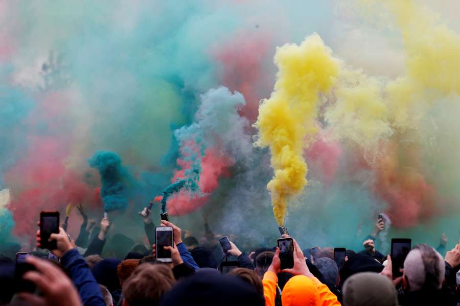 Manchester United fans with flares protest against their owners