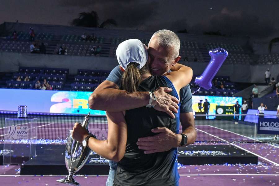 Iga Swiatek wird nach dem Sieg bei den WTA-Finals 2023 von ihrem Vater umarmt.