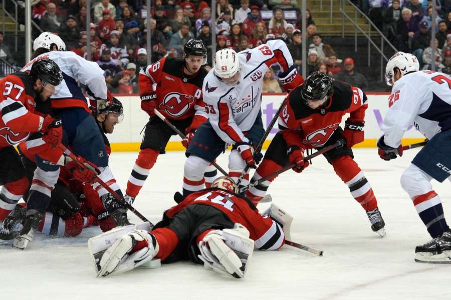 Washington Capitals and New Jersey Devils battle for the puck