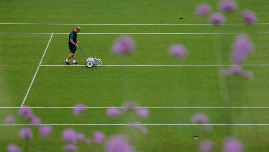 A member of staff tends to the lines on the court ahead of the day's matches