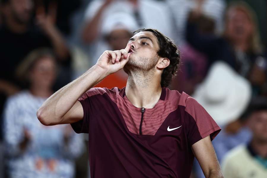 Taylor Fritz gestures to the French Open fans watching his match
