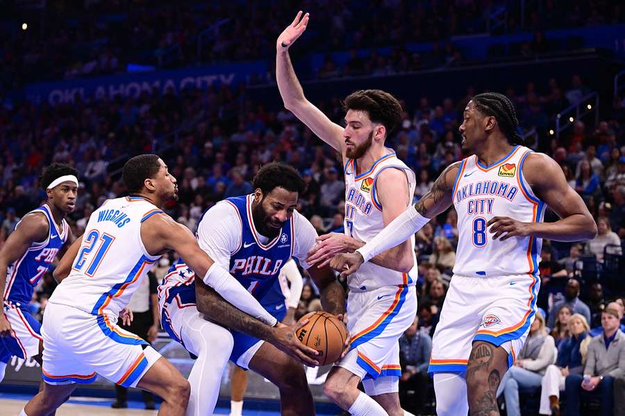 Andre Drummond of the Philadelphia 76ers battles for the ball with Aaron Wiggins and Chet Holmgren of the Oklahoma City Thunder