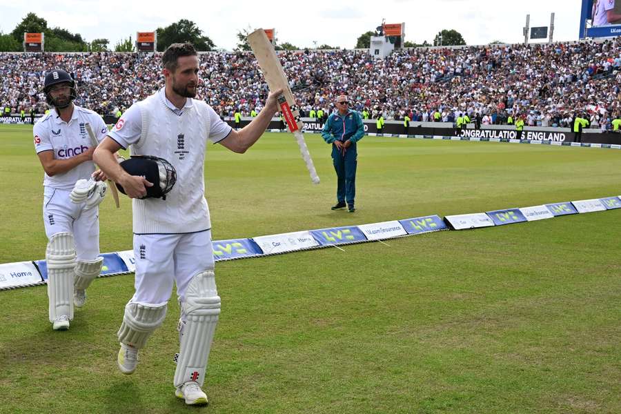 England's Chris Woakes (2L) and England's Mark Wood (L) leave the field after guiding England to victory