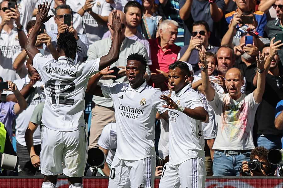 Vinicius Junior (C) celebrates with Real Madrid's Eduardo Camavinga (L) and Rodrygo (R)