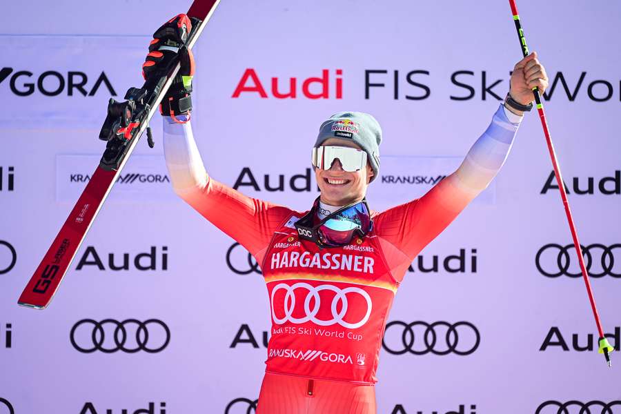 Marco Odermatt celebrates on the podium after his giant slalom win