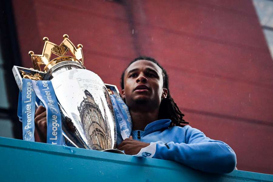 Nathan Ake holds the Premier League trophy