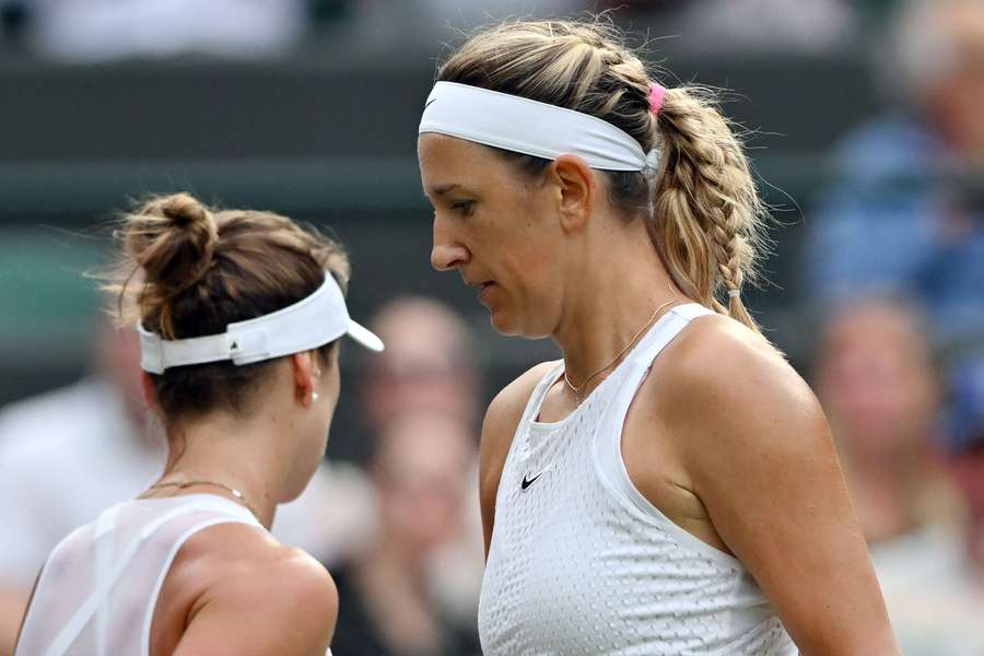 Belarus' Victoria Azarenka (R) passes by Ukraine's Elina Svitolina during their women's singles tennis match 