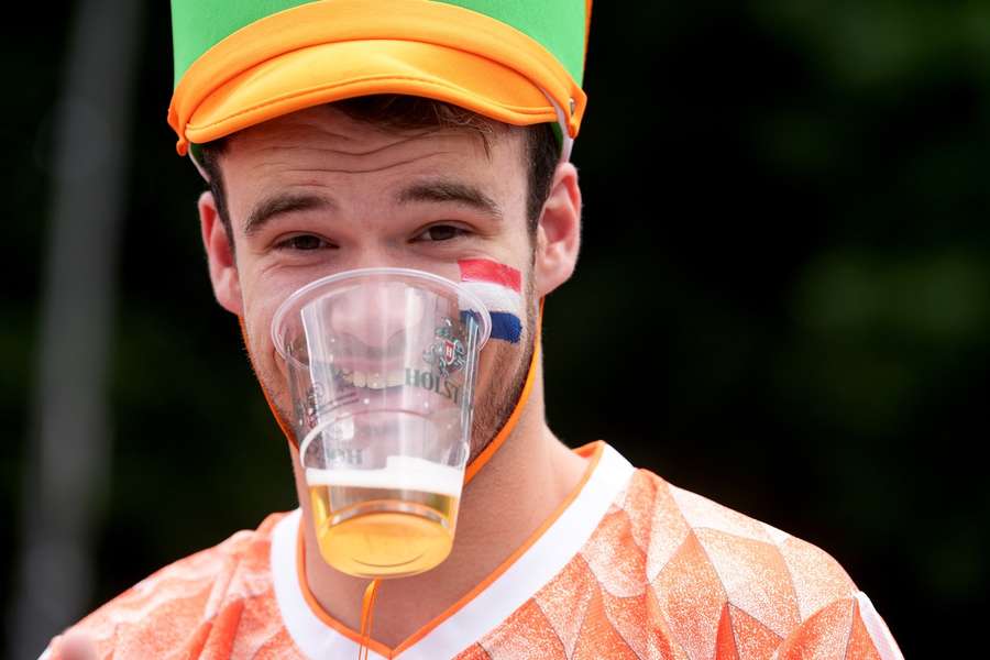 Um adepto neerlandês com o seu copo de cerveja