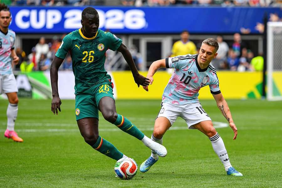 Pape Gueye (L) is pressed by Leandro Trossard (R)