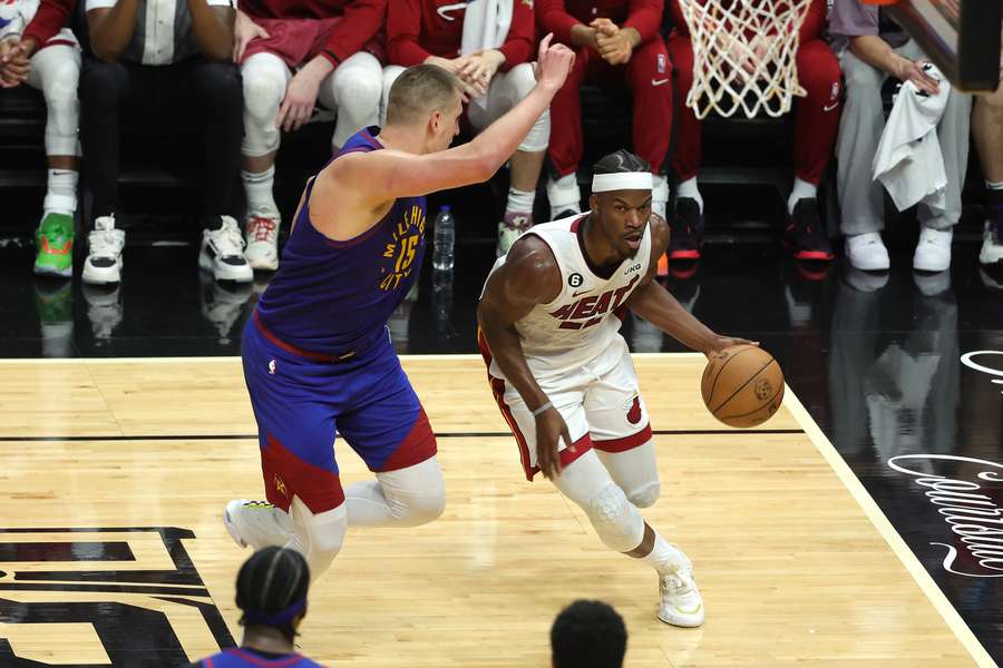 Jimmy Butler of the Miami Heat drives to the basket against Nikola Jokic of the Denver Nuggets