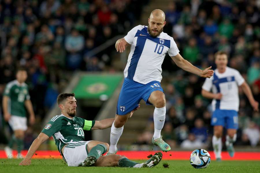 Northern Ireland's defender Craig Cathcart tackles Finland's striker Teemo Pukki 