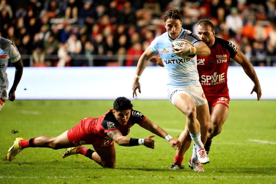 Racing 92's English winger Henry Arundell (C) avoids a tackle