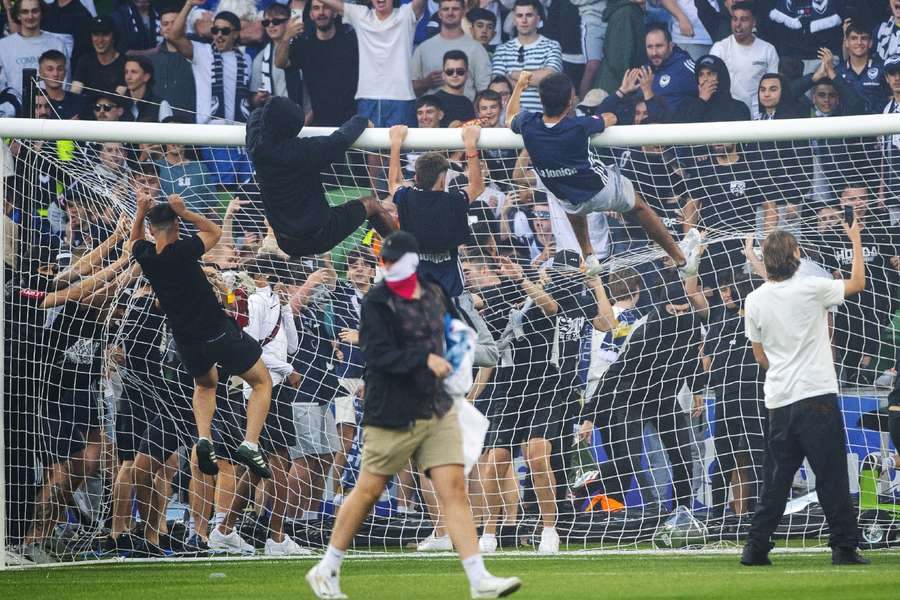 Hooligans betreden het veld tijdens de derby van Melboure op 17 december 2022