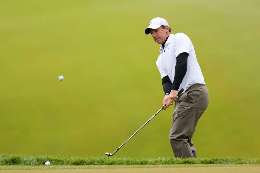 Rory McIlroy of Northern Ireland chips onto the 18th green