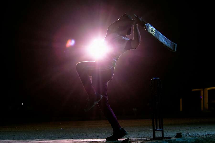 Cricketer Arbaz Khan plays a shot during the tape ball night cricket tournament during the Muslim holy fasting month of Ramadan in Karachi