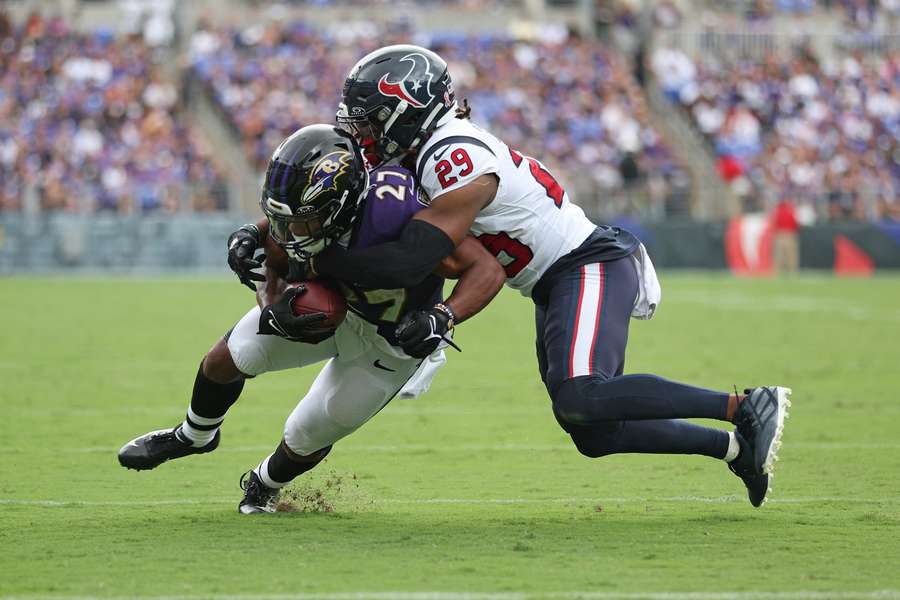 J.K. Dobbins (l.) in duel met M.J. Stewart van de Texans