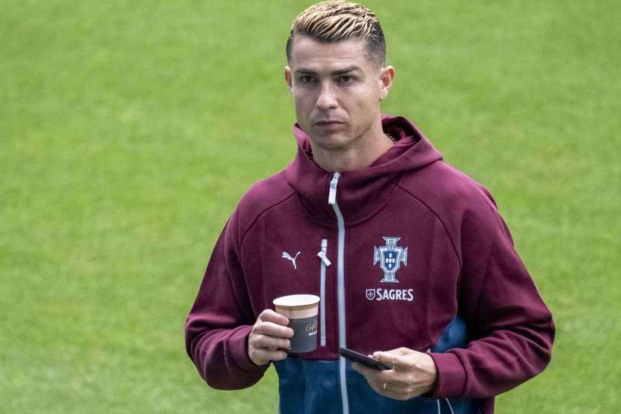 CR7 mit Kaffeebecher und Smartphone