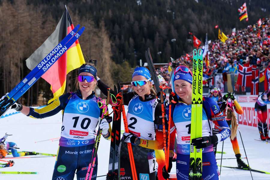 Franziska Preuss celebrates after winning the 10km Pursuit with second-placed Elvira Oeberg and third-placed Justine Braisaz-Bouchet