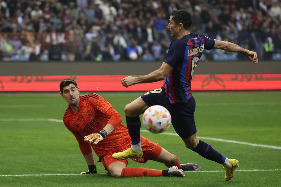 Barcelona's Polish forward Robert Lewandowski fights for the ball with Real Madrid's Belgian goalkeeper Thibaut Courtois