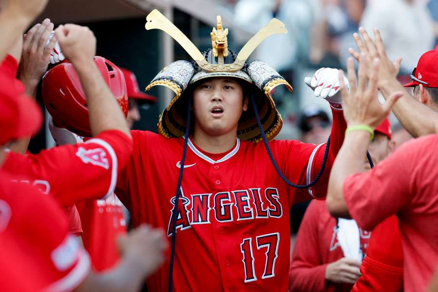 Shohei Ohtani celebrates with teammates after he hits a home run in the fourth inning against the Detroit Tigers