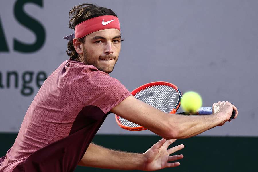 Taylor Fritz plays a backhand return to France's Arthur Rinderknech during their men's singles match on day five of the Roland-Garros Open tennis tournament