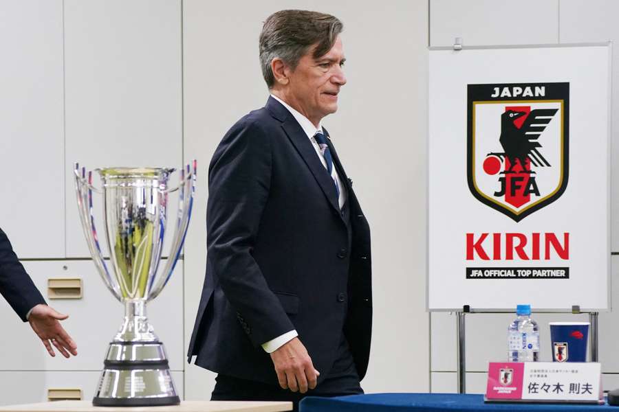 Japan manager Nils Nielsen walks past the Asian Cup trophy at a post-tournament press conference. 