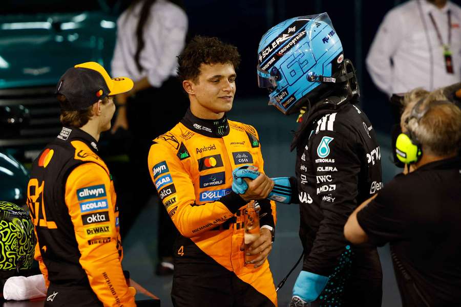 Lando Norris, centre, congratulates George Russell as Oscar Piastri watches on