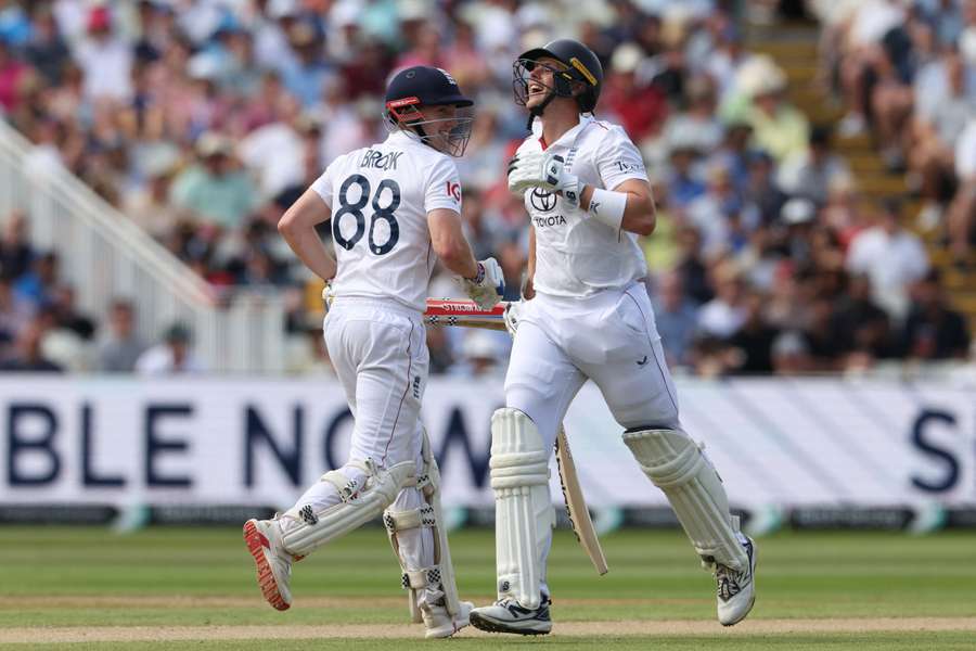 England's Harry Brook and Jamie Smith (R) share a joke as they take a run on day three of the second Test against India
