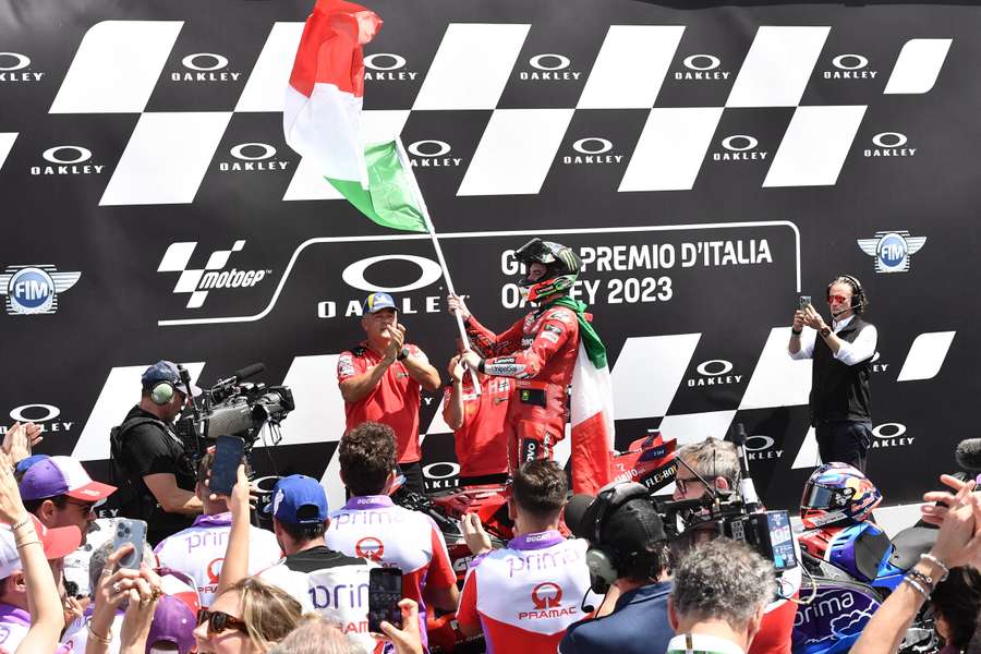 Francesco Bagnaia waves the Italian flag at his home grand prix of Mugello