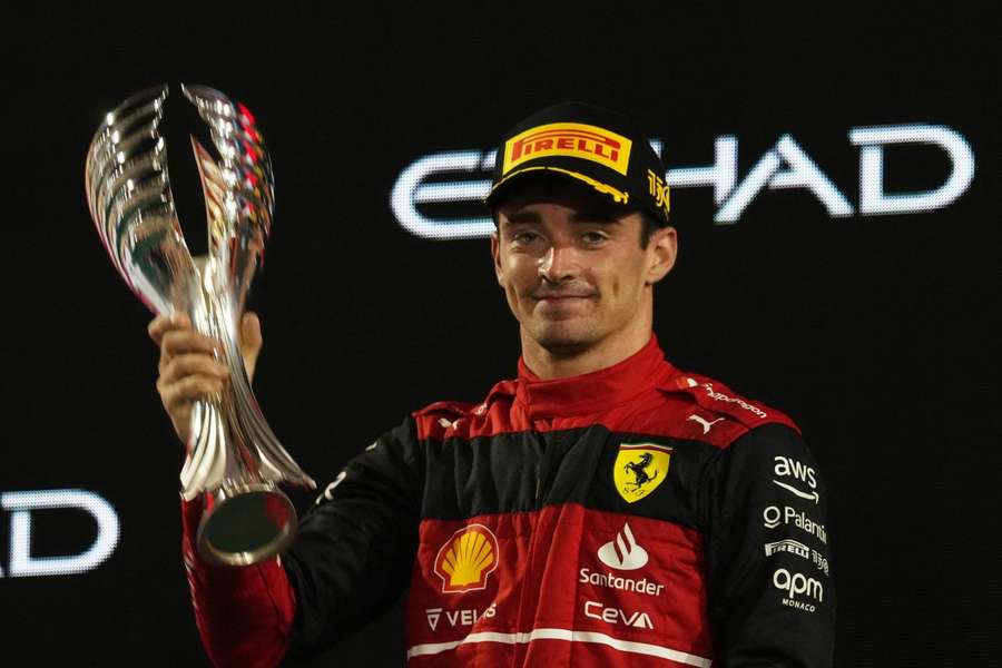 Ferrari's Charles Leclerc celebrates with a trophy on the podium after finishing in second place in Abu Dhabi