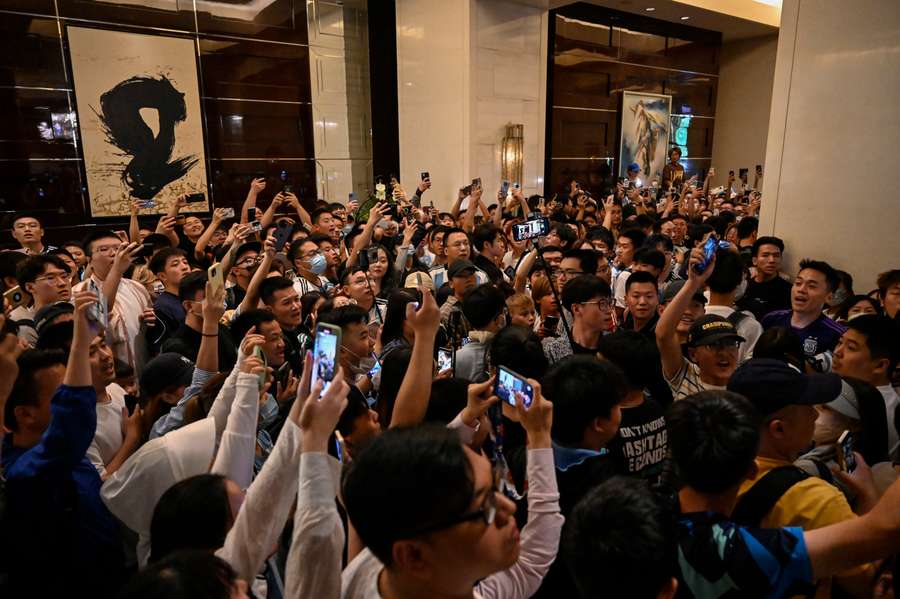 Fans rush to see the arrival of the Argentine national football team at the Four Seasons Hotel in Beijing