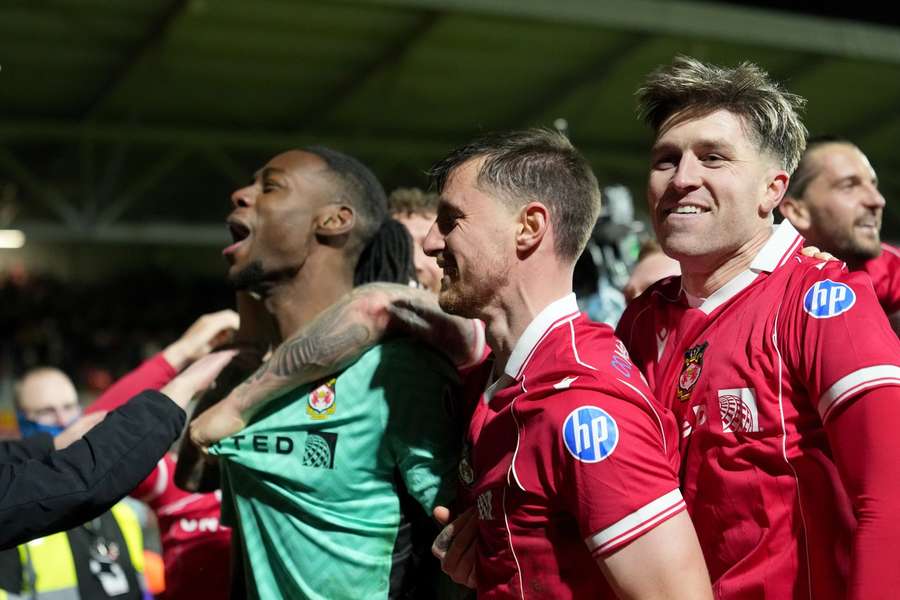 Wrexham goalkeeper Arthur Okonkwo (L) celebrates with teammates