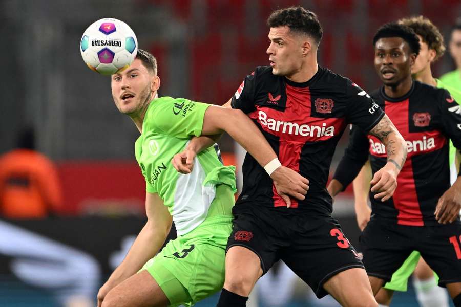Leverkusen's Granit Xhaka and Wolfsburg's Jonas Wind fight for the ball