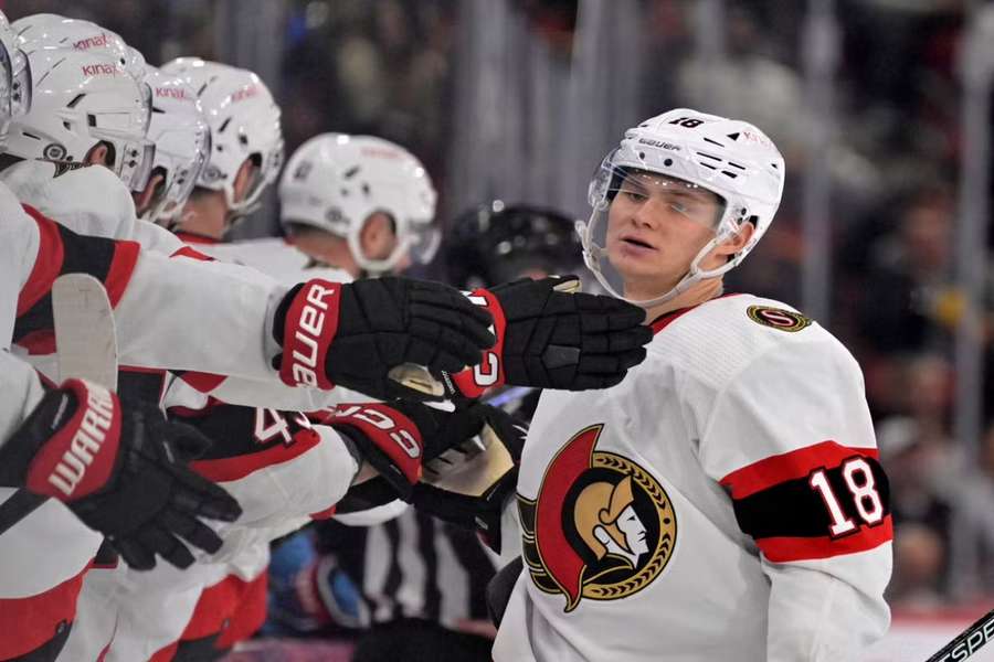 Stutzle celebrates with teammates after scoring a goal