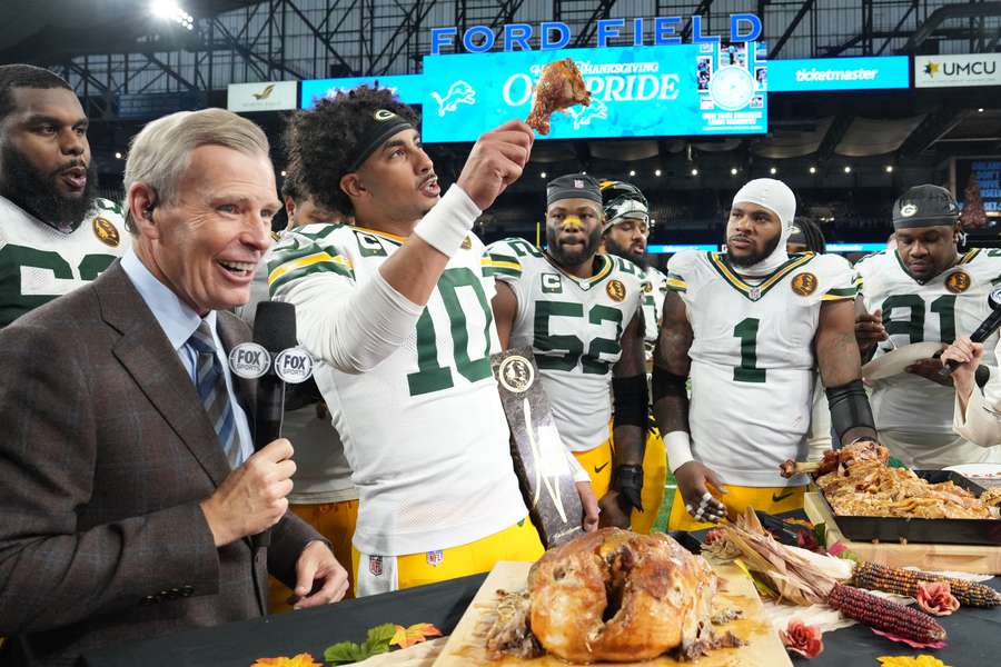 Jordan Love hoists a piece of chicken in the air after leading the Green Bay Packers to victory.