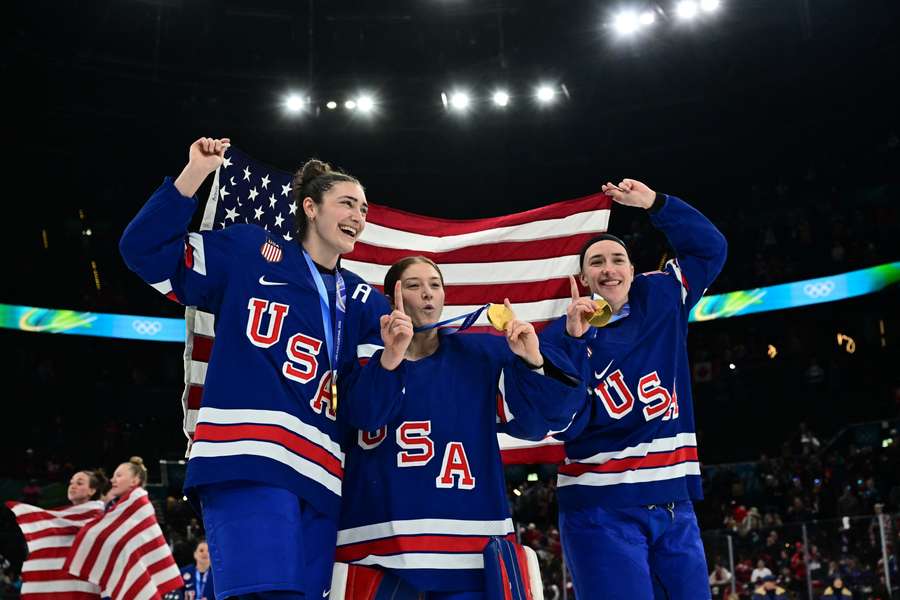USA Women's players pose with gold medal at 2026 Winter Olympics