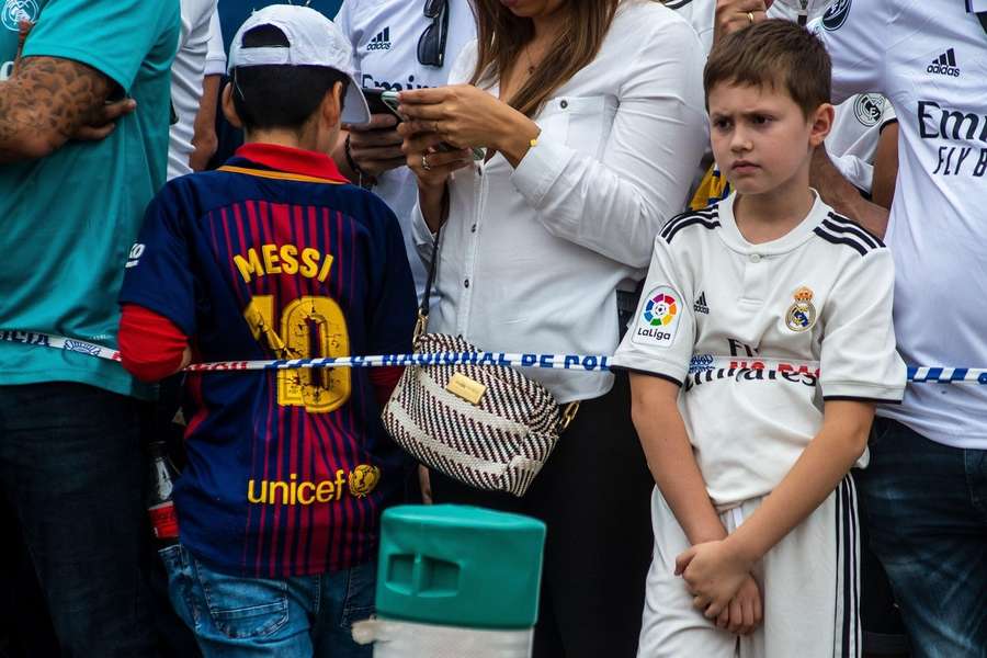 Dos niños con camisetas del Real Madrid y el FC Barcelona antes de un Clásico.