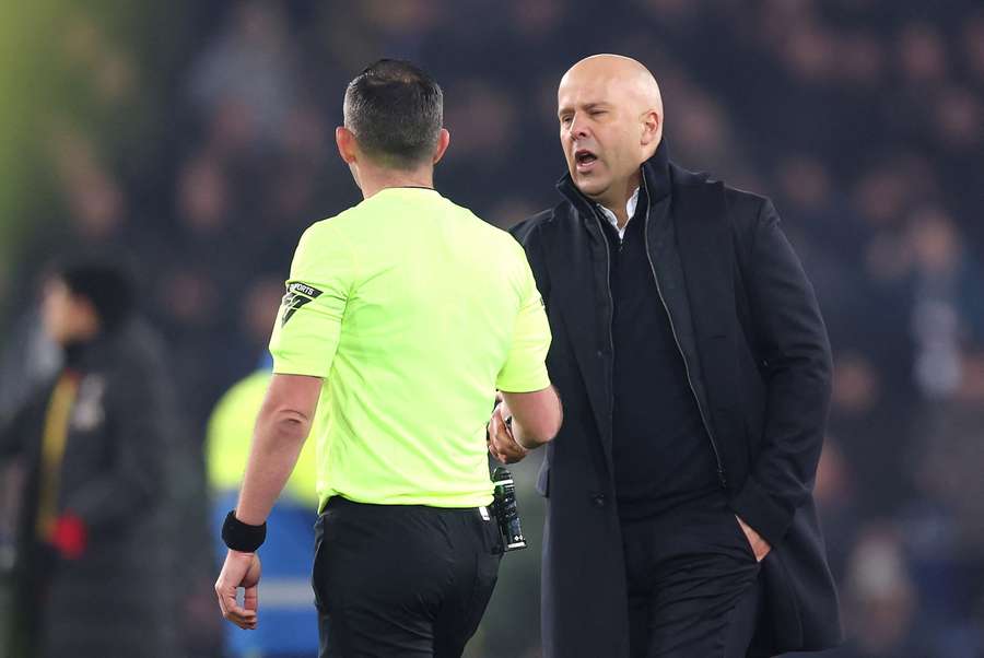 Arne Slot shakes hands with Michael Oliver before receiving his red card