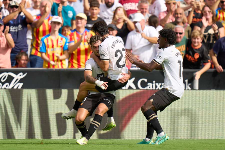 Hráči Valencie slaví jeden ze tří gólů do sítě Atlétika. 