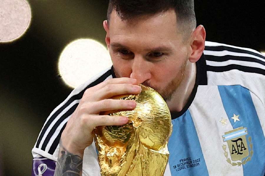 Lionel Messi kisses the World Cup trophy